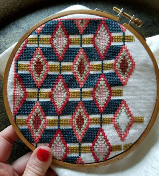 folk embroidery with repeating oval shape in embroidery hoop