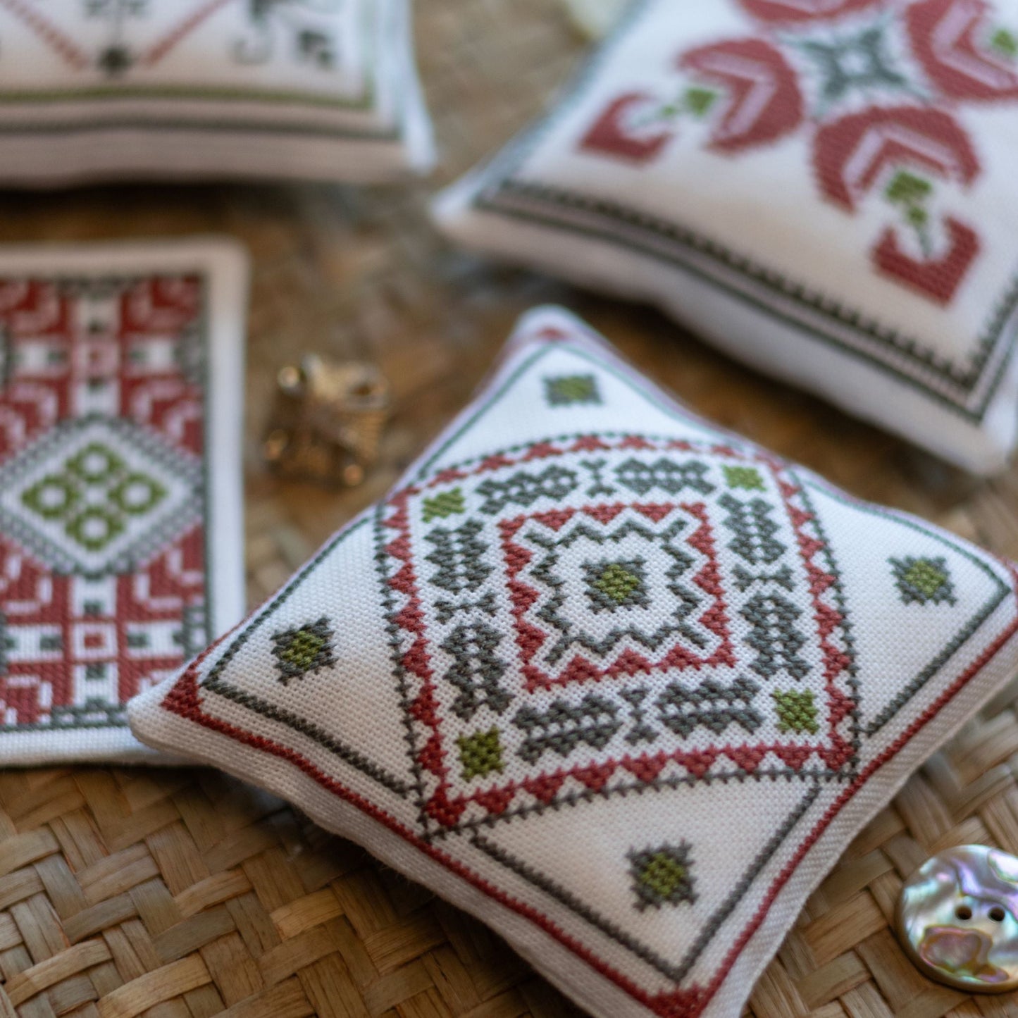 Decorative cross stitch ornaments with folk patterns on a woven placemat