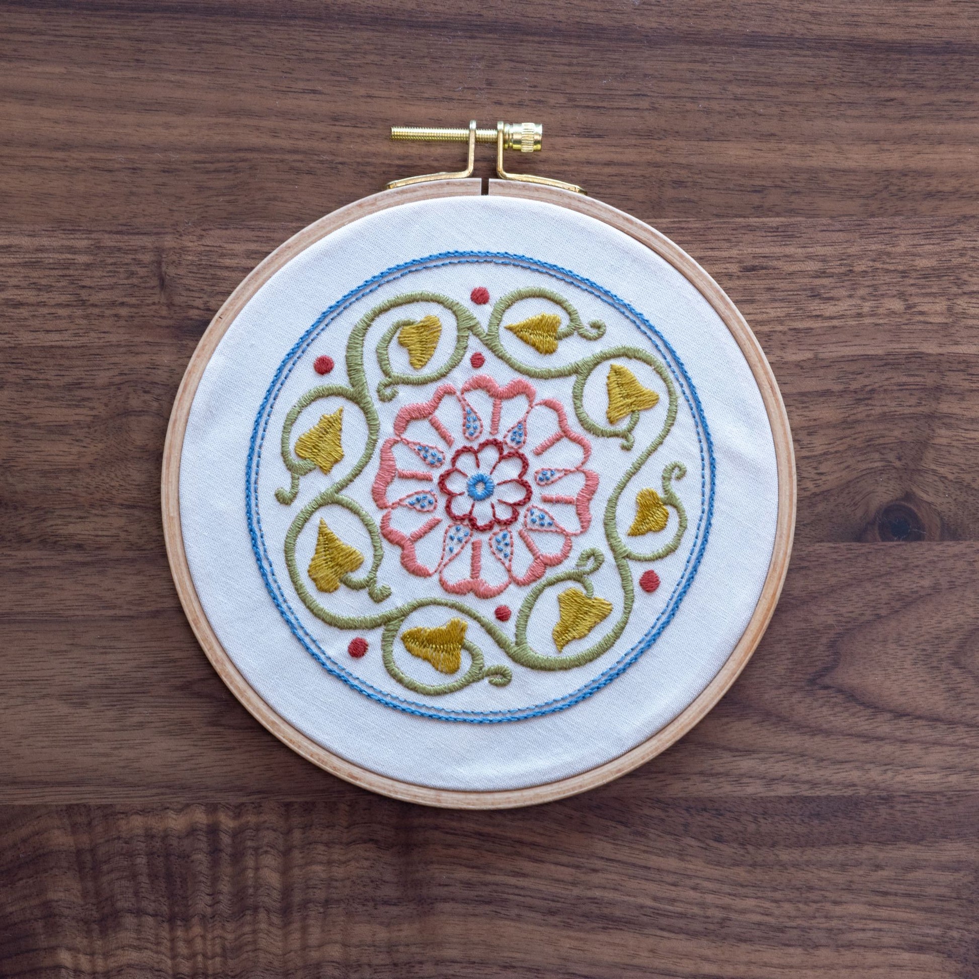 Embroidery hoop with floral design on a wooden surface