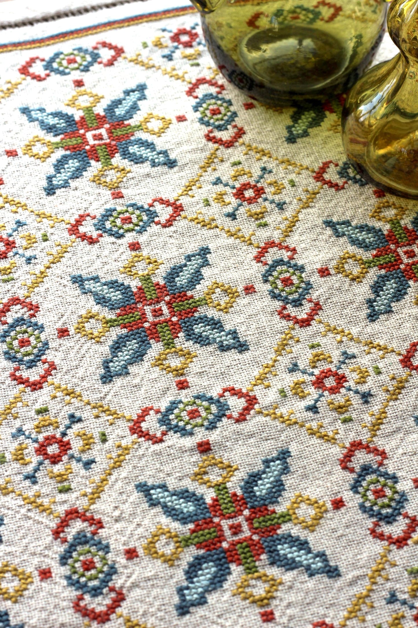 folk embroidery table runner with repeating star design in teal and terra cotta