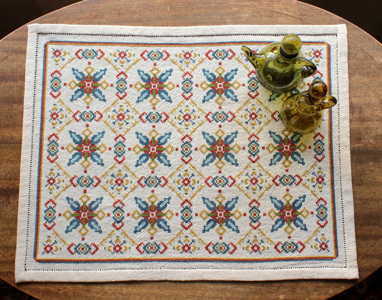 folk embroidery table runner with repeating star design in teal and terra cotta