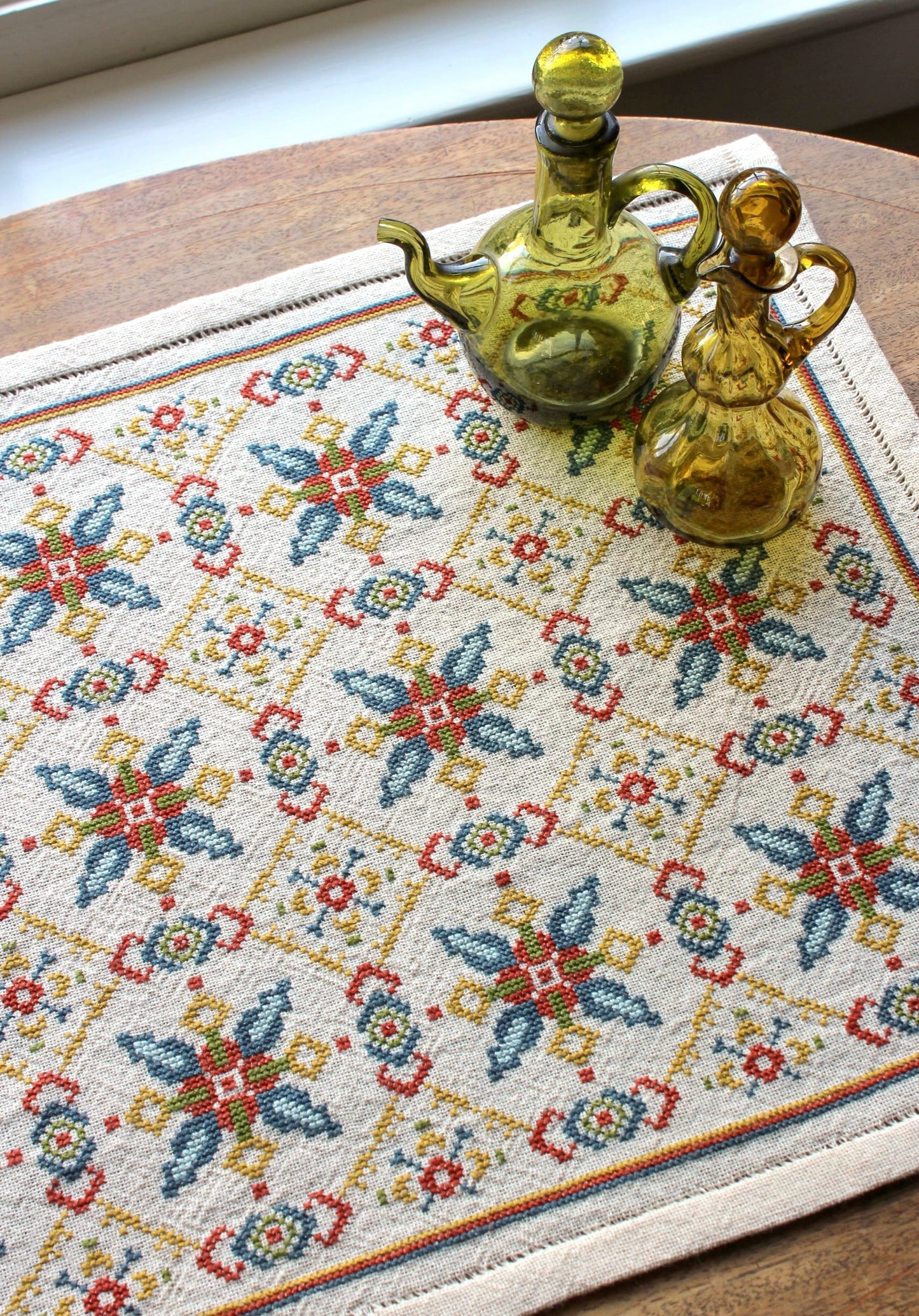 folk embroidery table runner with repeating star design in teal and terra cotta