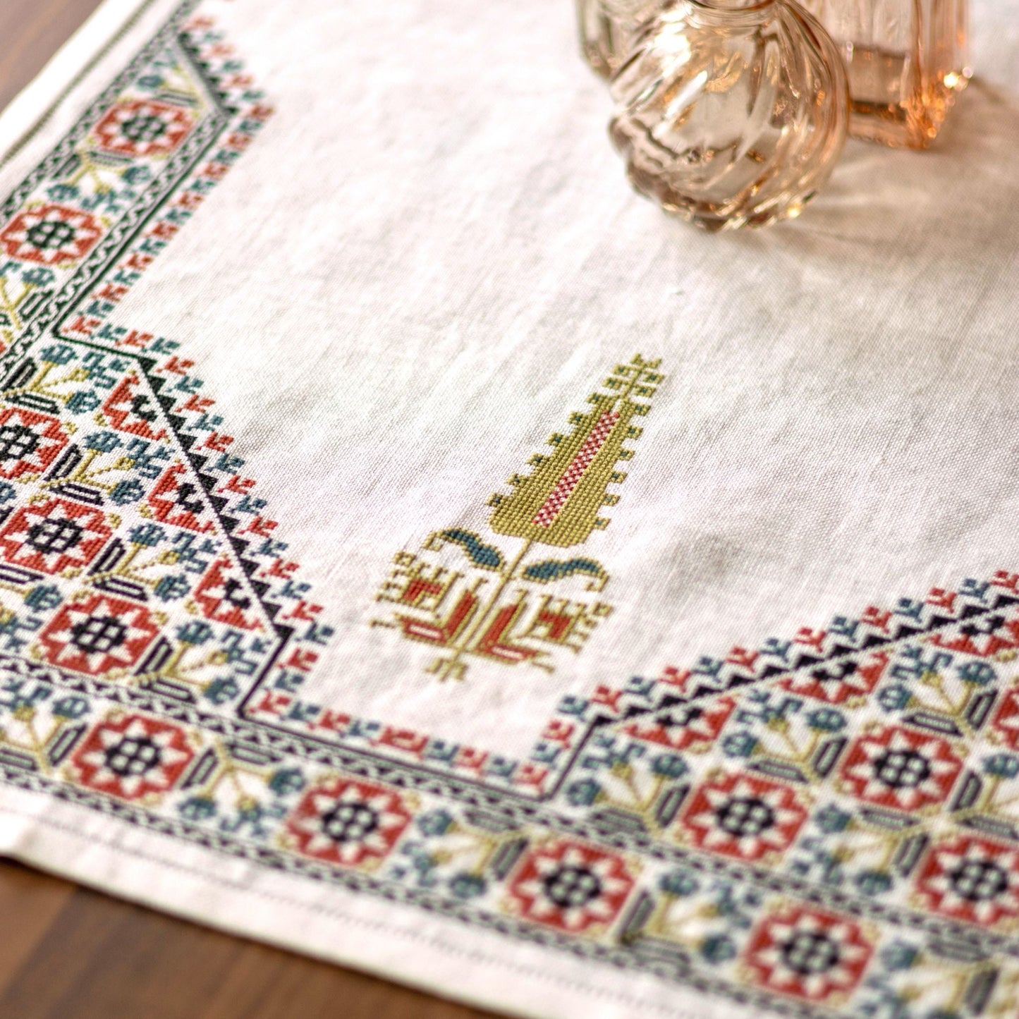 cross stitch folk embroidery table runner with stars, flowers, and cypress tree on white linen