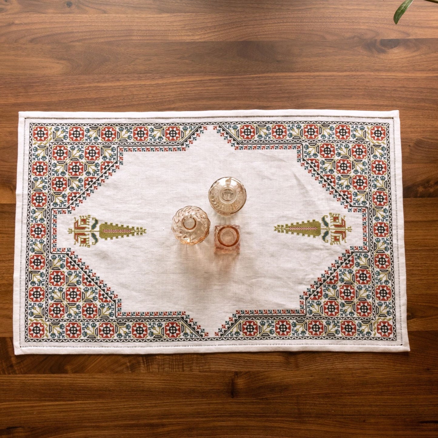 cross stitch folk embroidery table runner with stars, flowers, and cypress tree on white linen