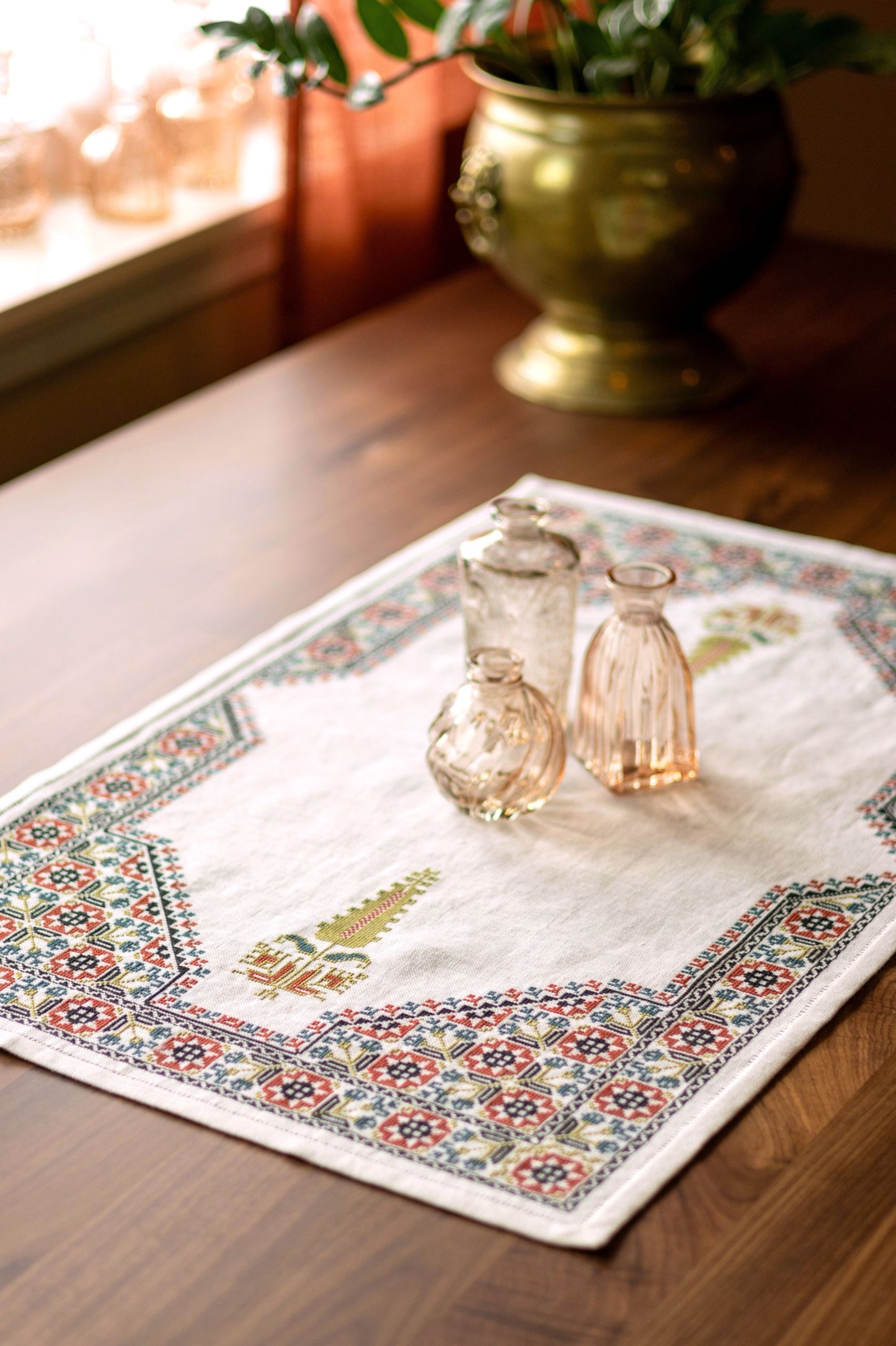 cross stitch folk embroidery table runner with stars, flowers, and cypress tree on white linen