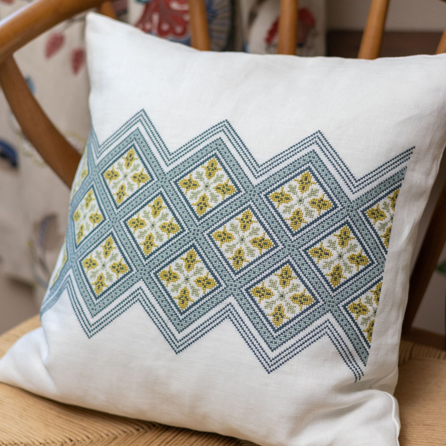 folk embroidery cushion with diamond design in blue