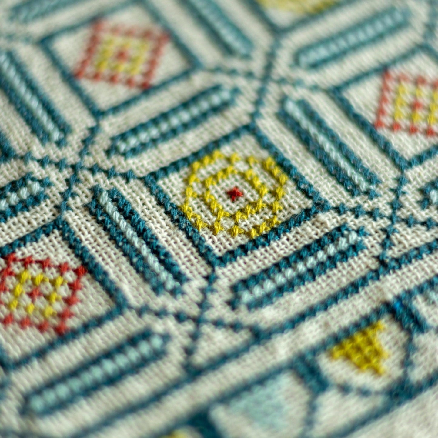folk embroidery cross stitch with repeating tile design in blue