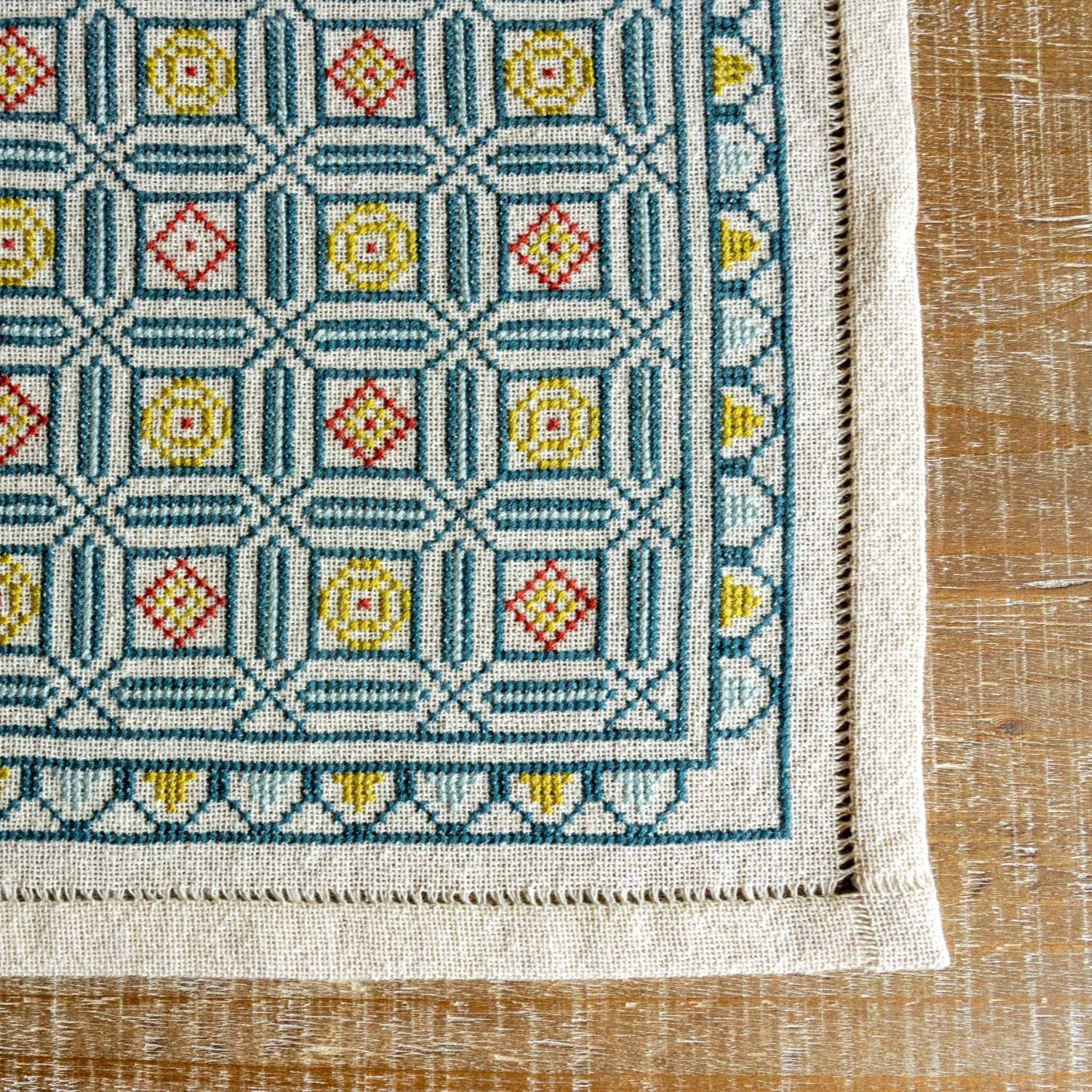 folk embroidery cross stitch with repeating tile design in blue