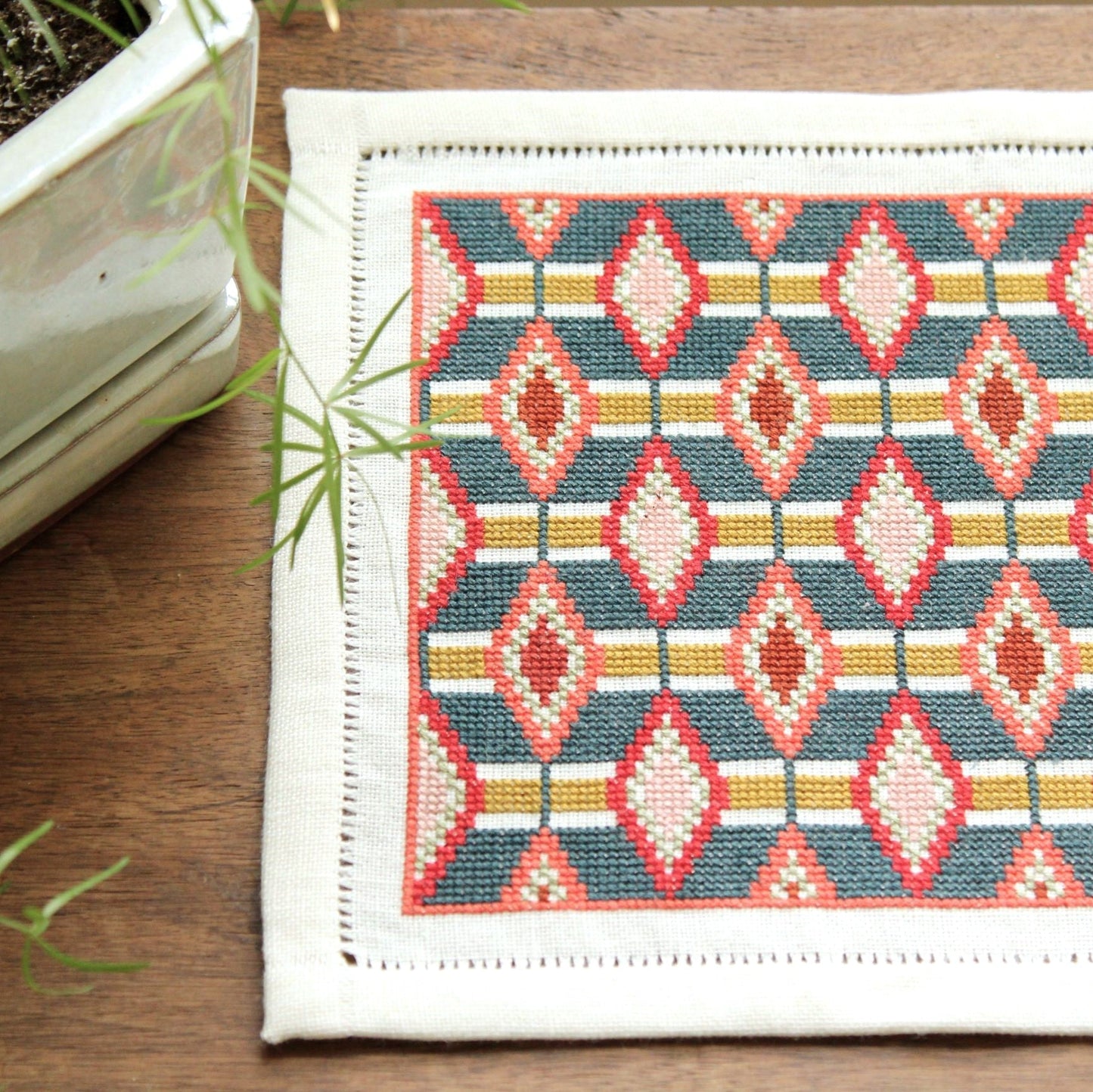 cross stitch folk embroidery table mat with repeating oval design
