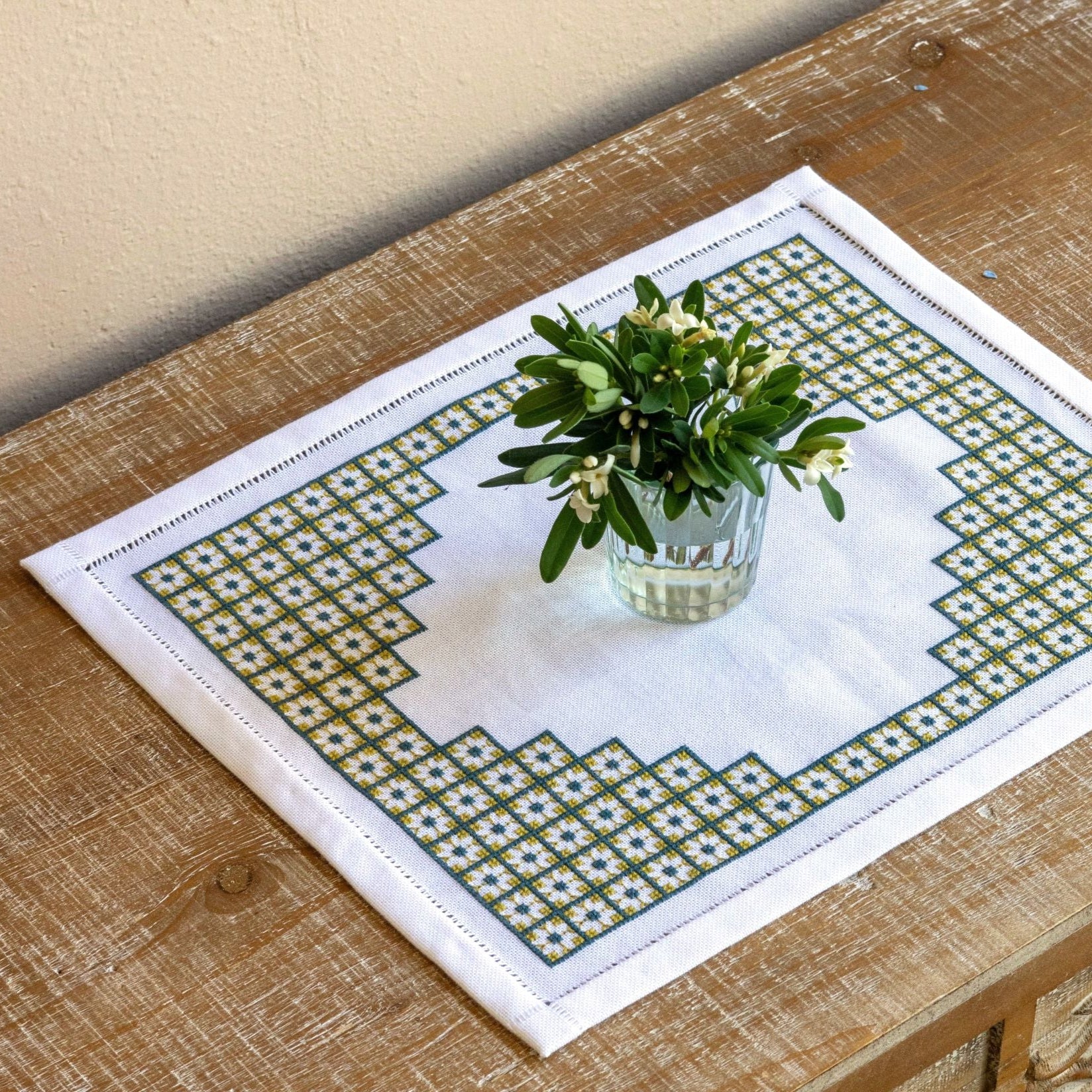 Decorative placemat with floral arrangement on a wooden table