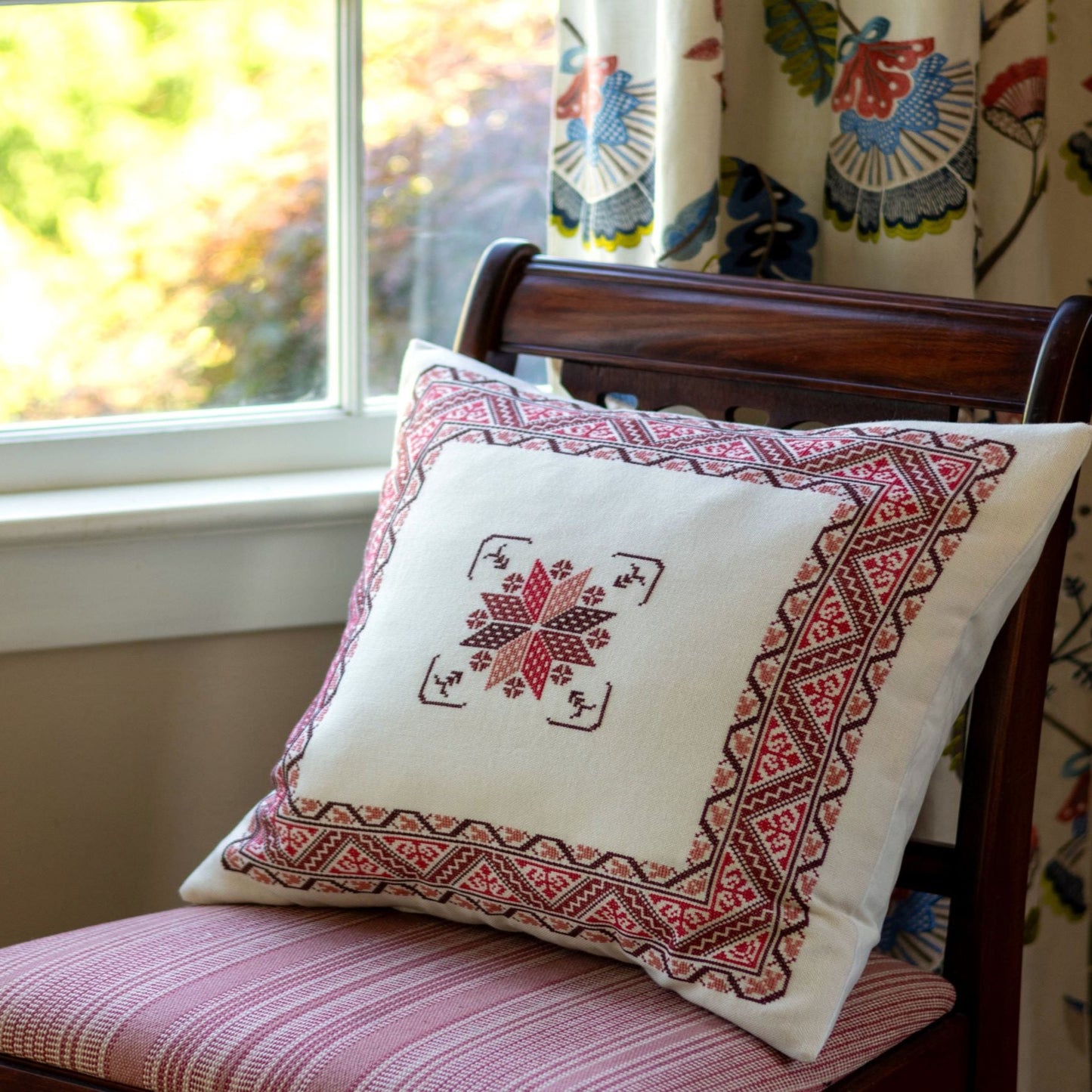 folk embroidery cushion with red border design