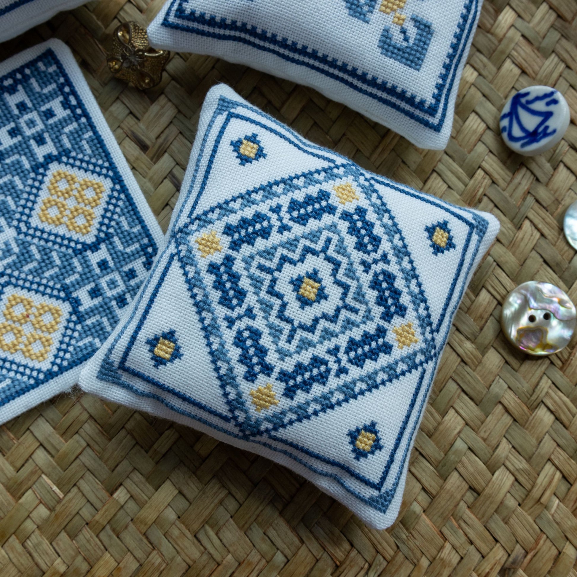 Cross-stitch ornament with geometric patterns on a woven placemat