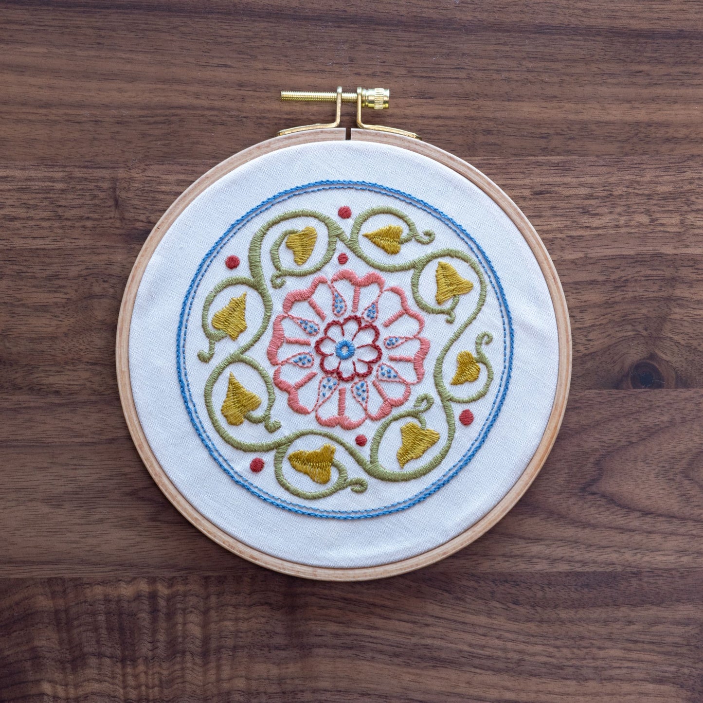 Embroidery hoop with floral design on a wooden surface