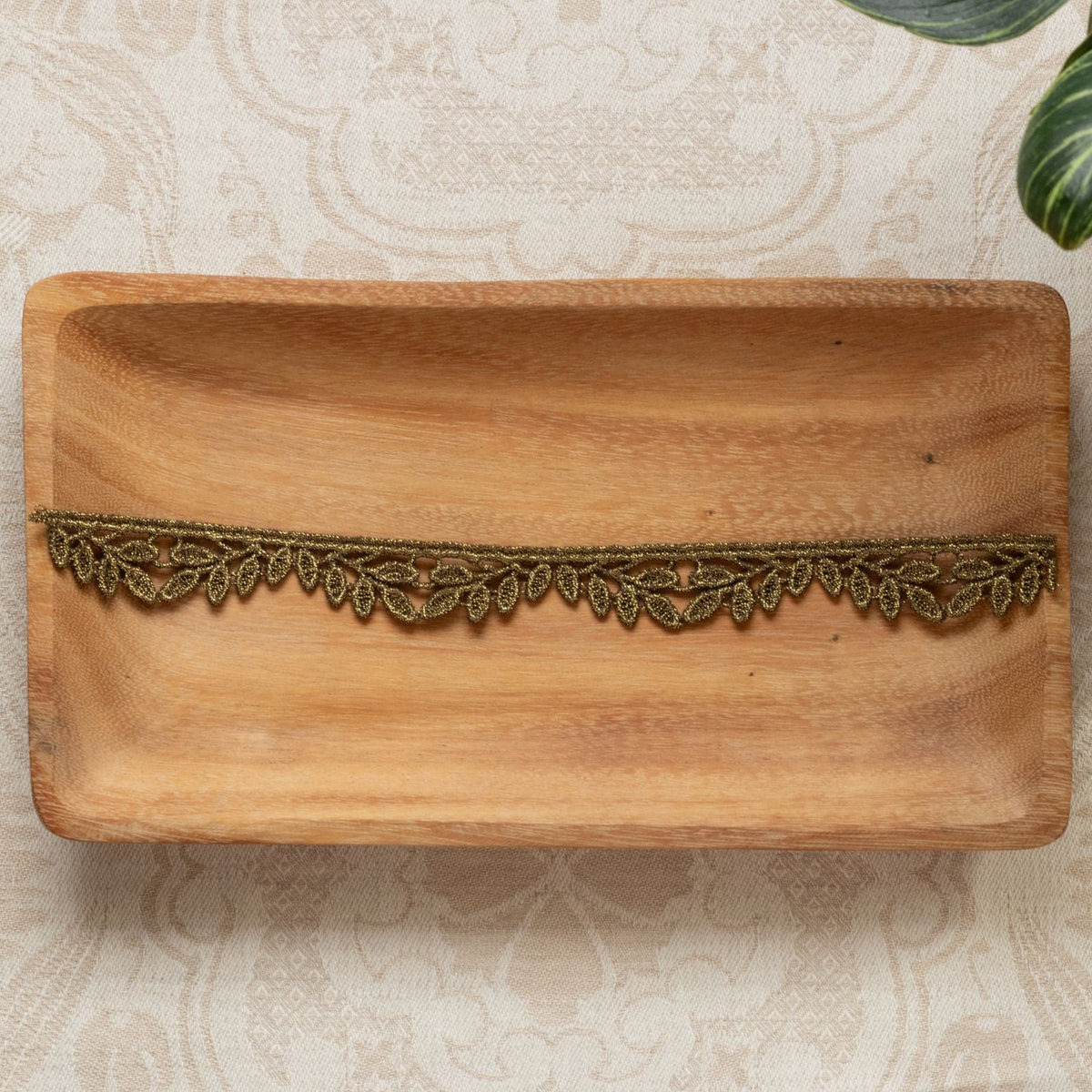 metallic trim with leaf design on wooden tray