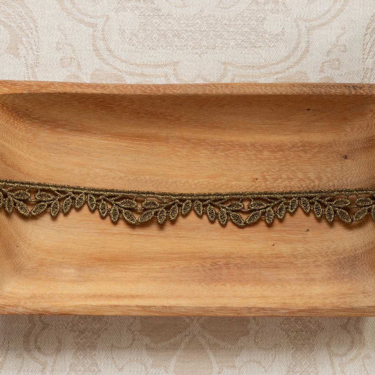 metallic trim with leaf design on wooden tray