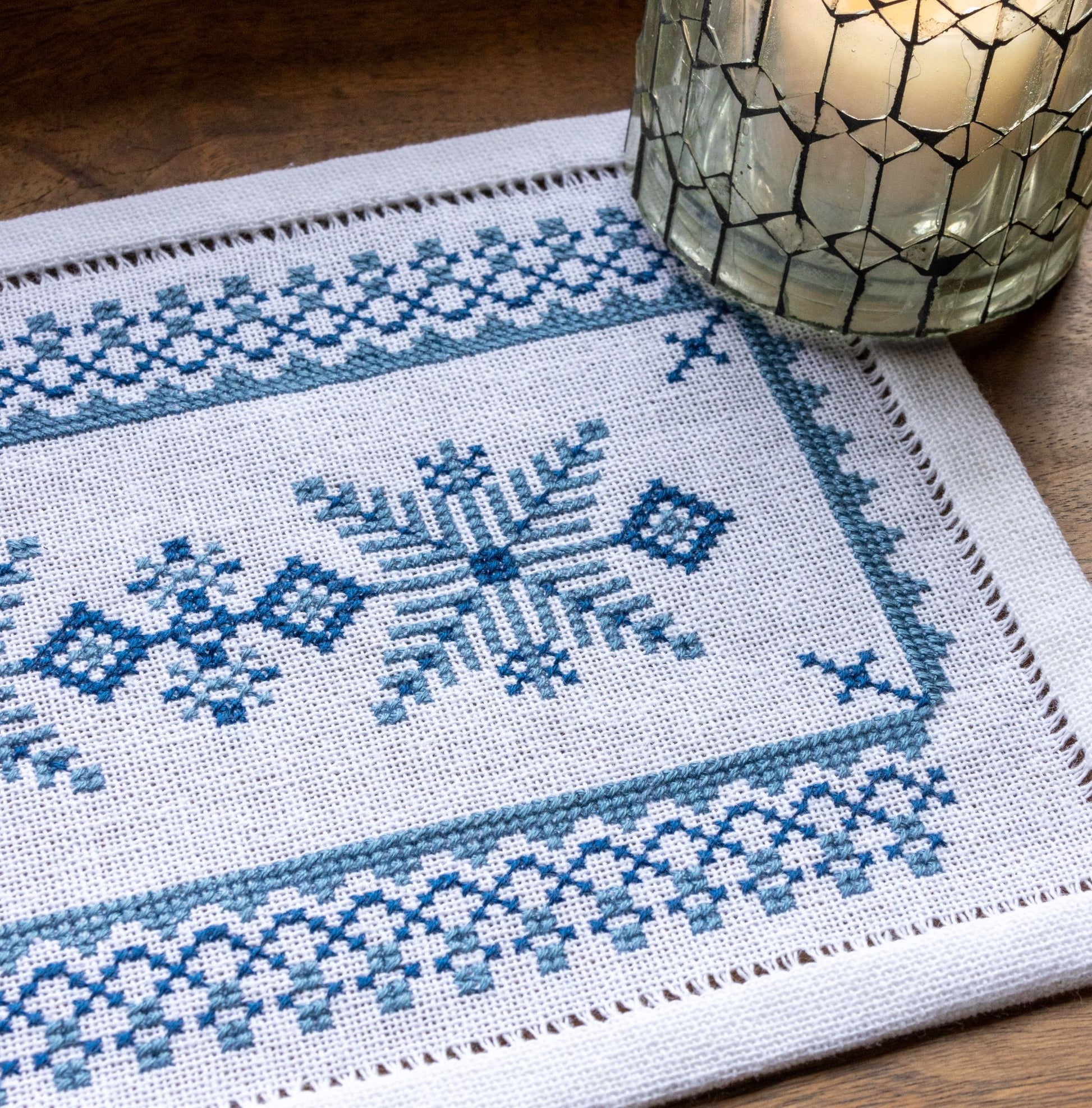 folk embroidery on white traditional fabric with star design and candle