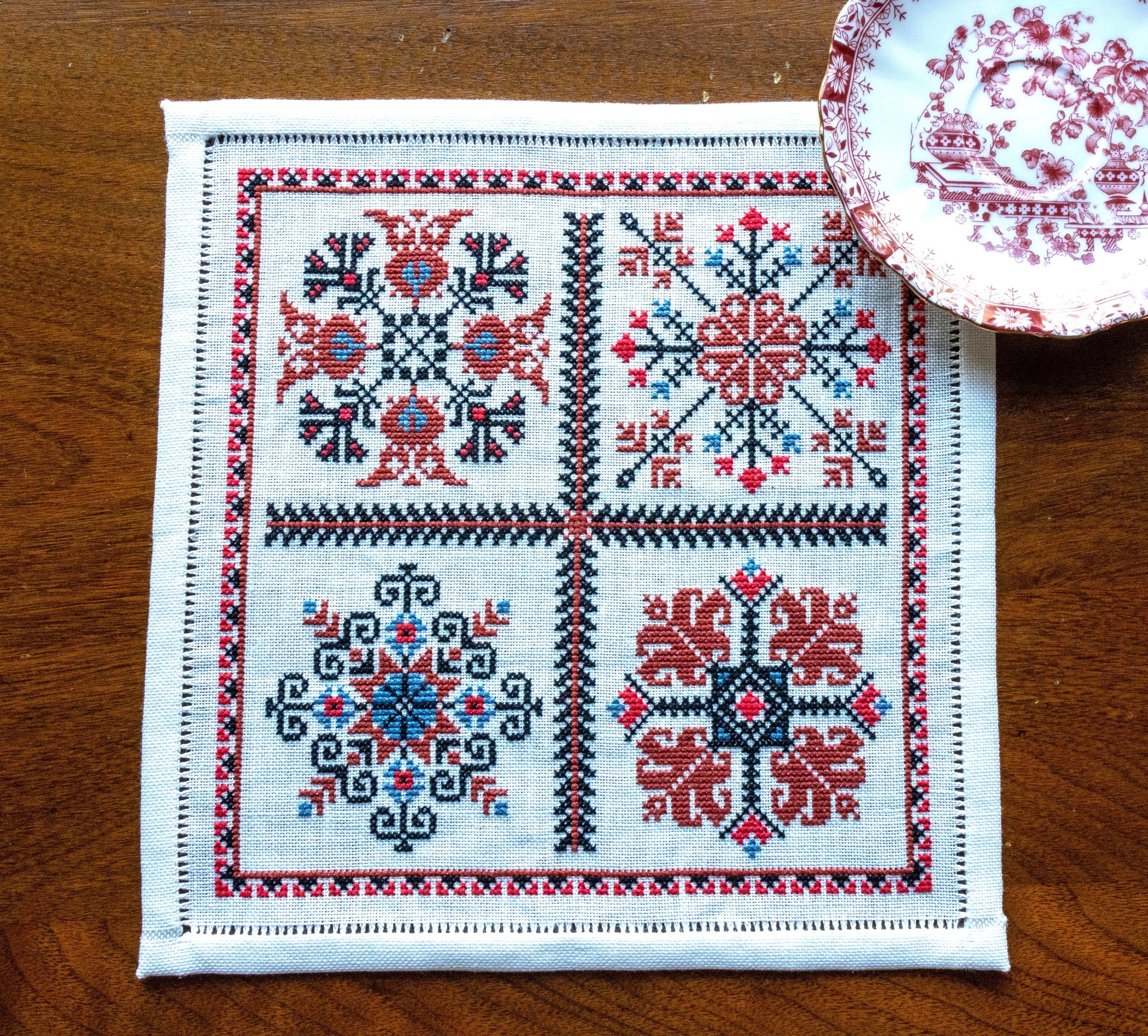 folk embroidery with four red and black motifs