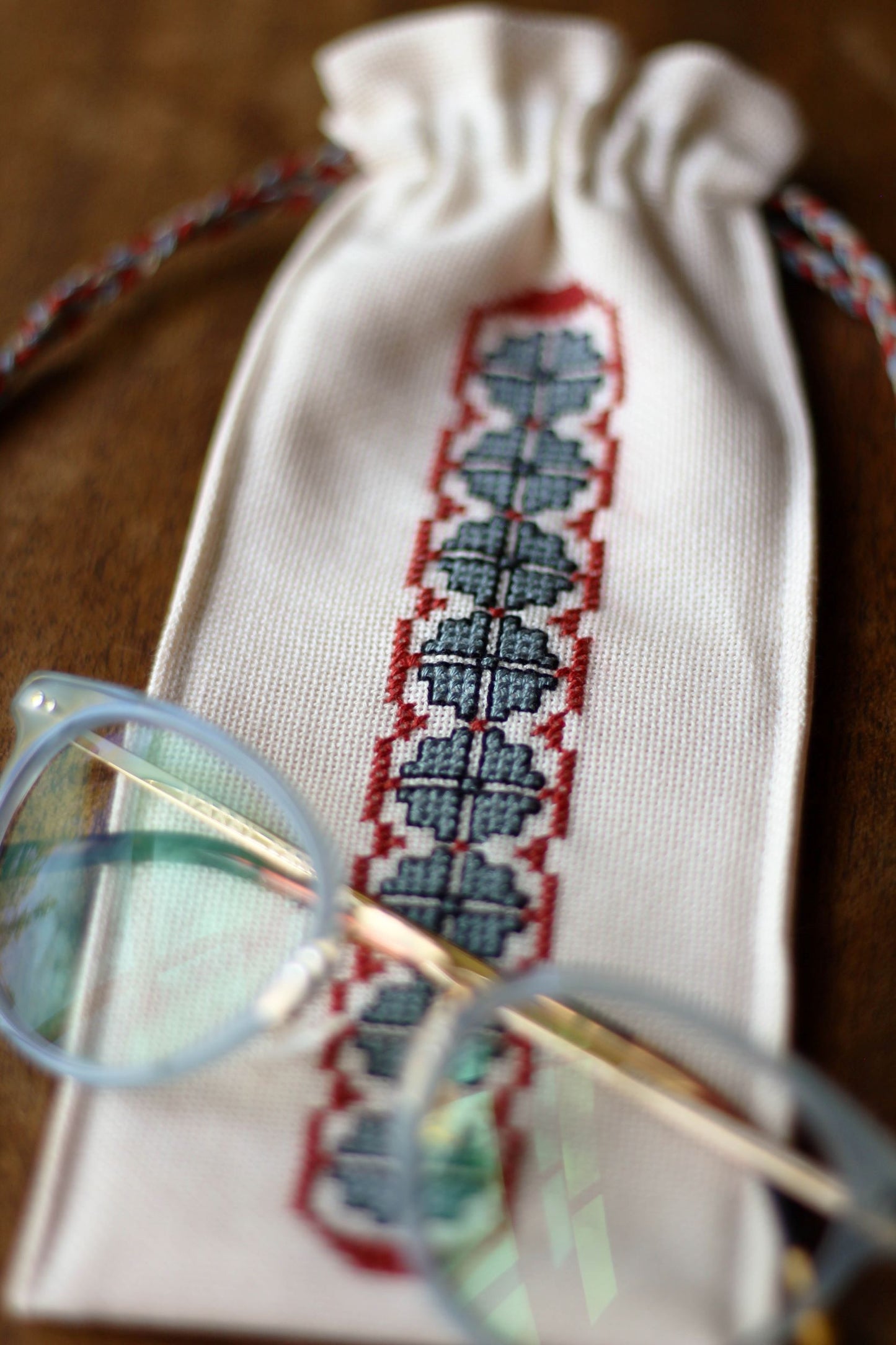 small drawstring bag with folk embroidery border and glasses