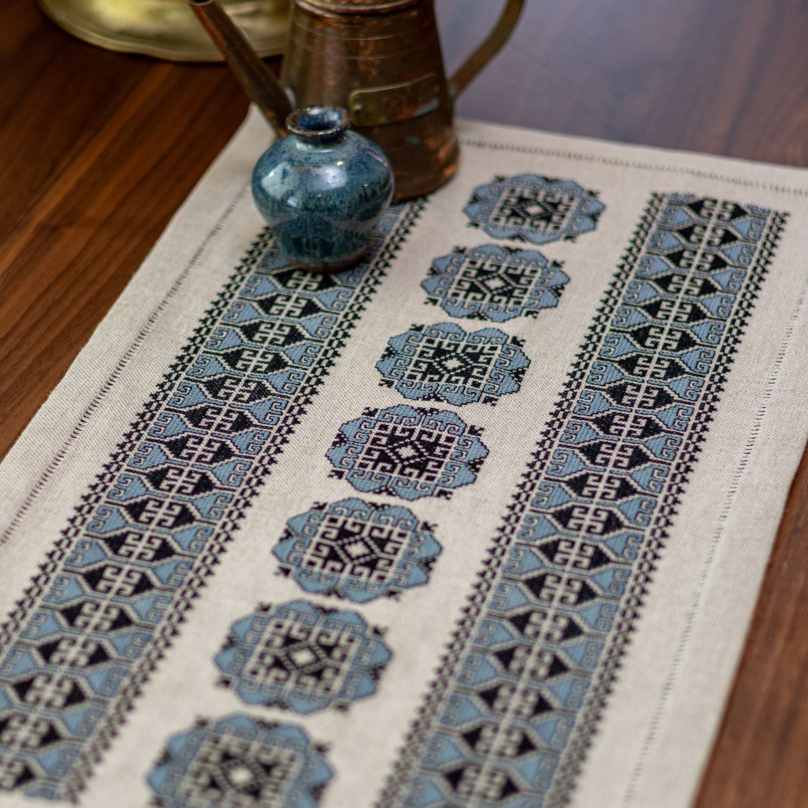 Embroidered table runner with geometric patterns on a wooden surface