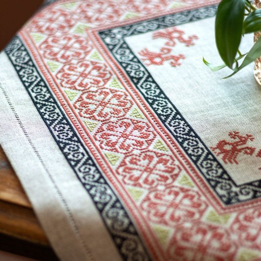 Greek folk embroidery in red and black on wooden table