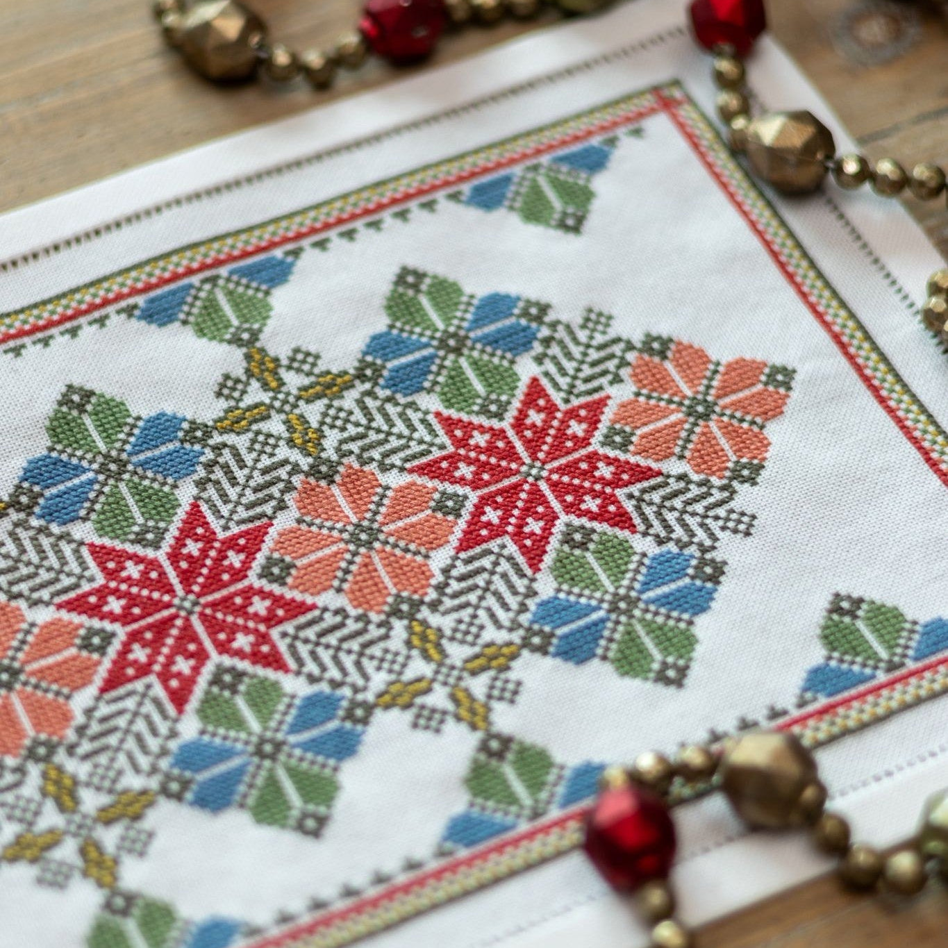 cross stitch folk embroidery with star and flower design in red and blue