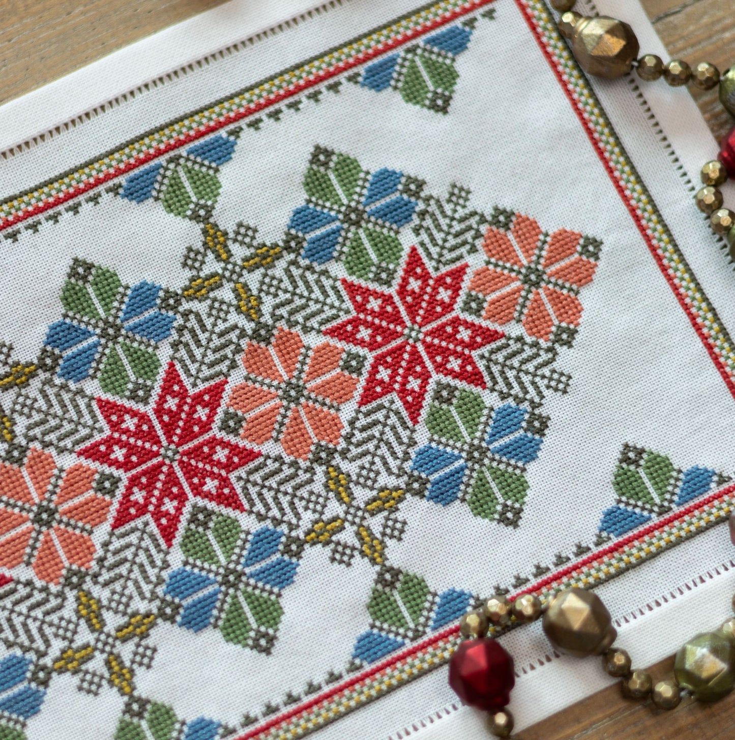 cross stitch folk embroidery with star and flower design in red and blue