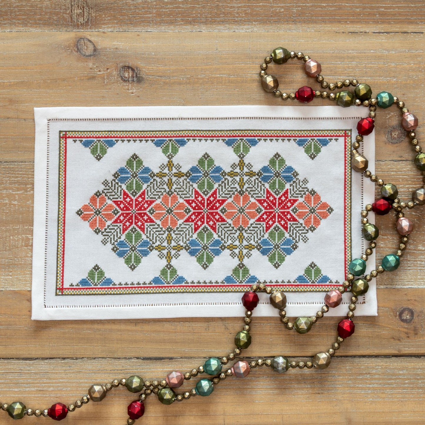 cross stitch folk embroidery with star and flower design in red and blue