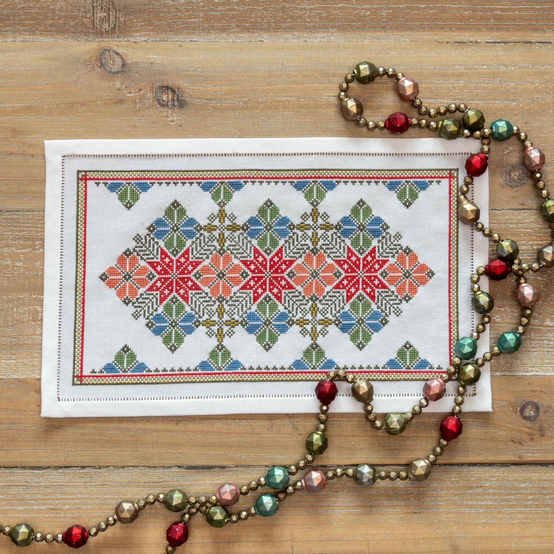 cross stitch folk embroidery with star and flower design in red and blue