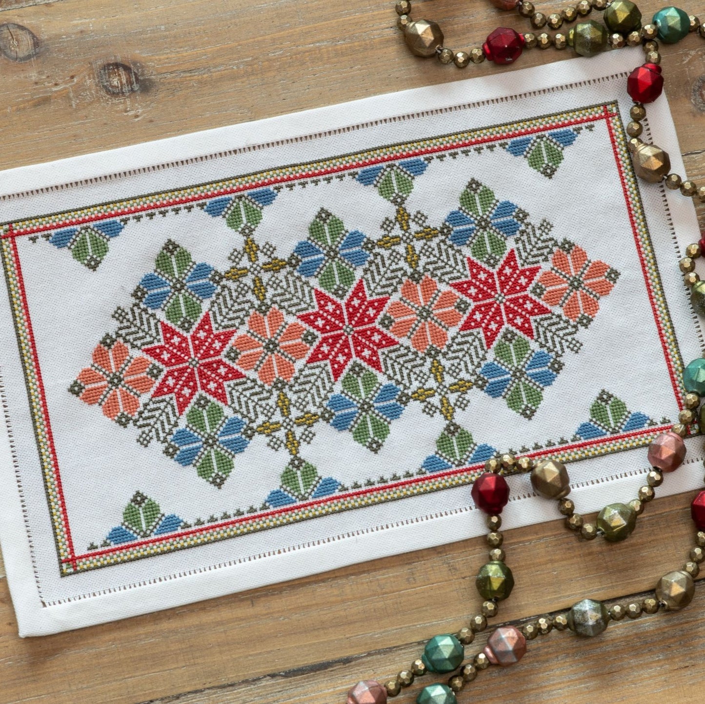cross stitch folk embroidery with star and flower design in red and blue