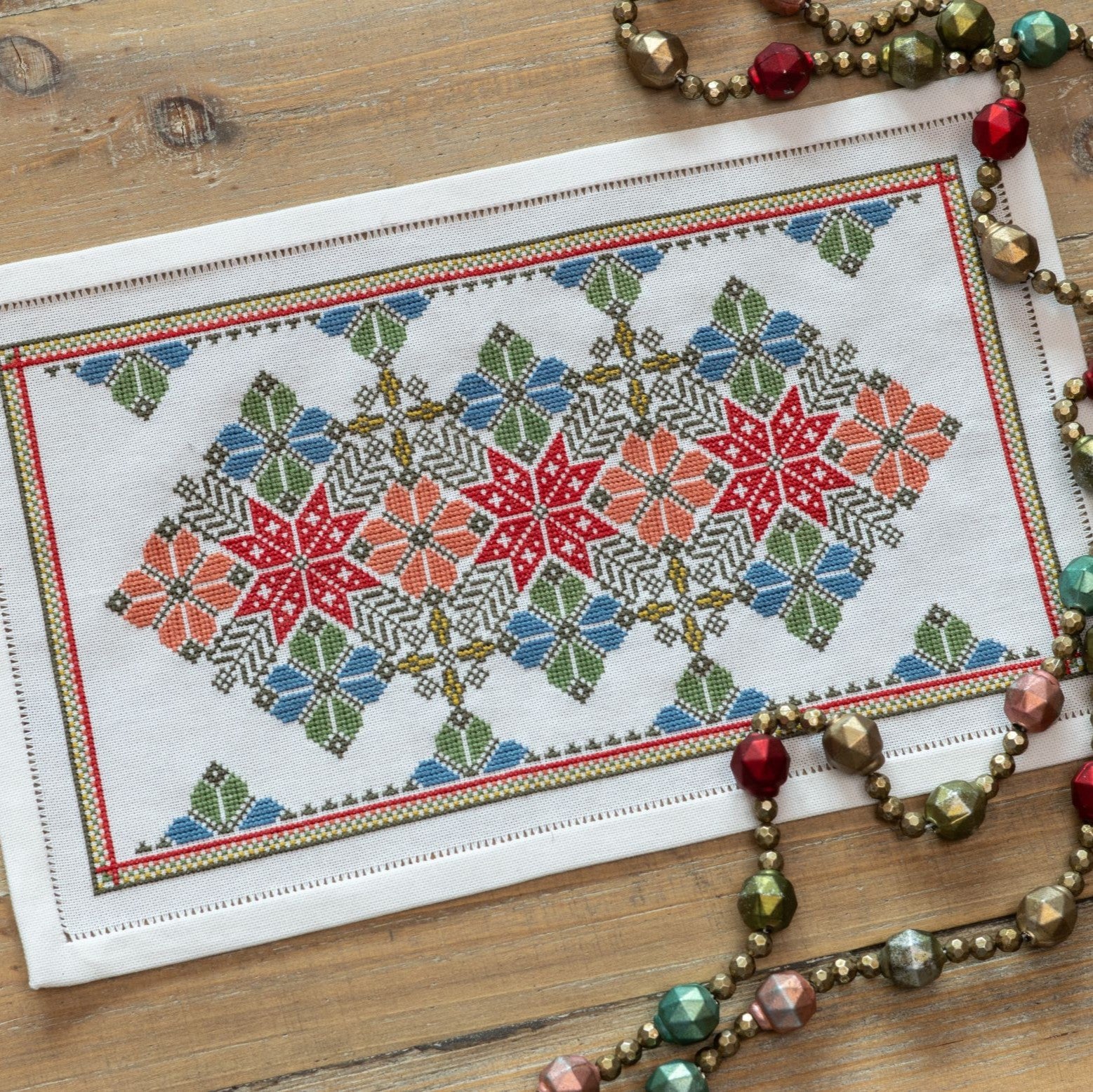 cross stitch folk embroidery with star and flower design in red and blue