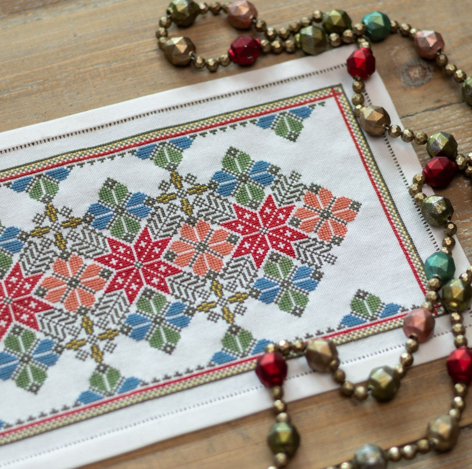 cross stitch folk embroidery with star and flower design in red and blue