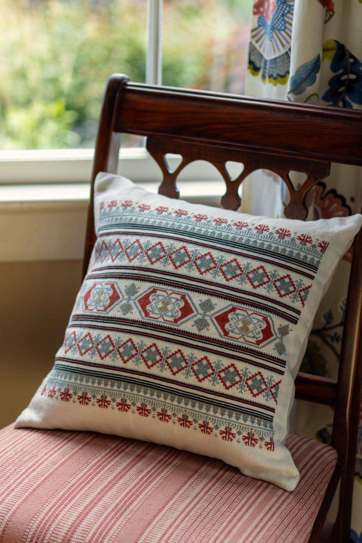 folk embroidery cushion with blue and red borders