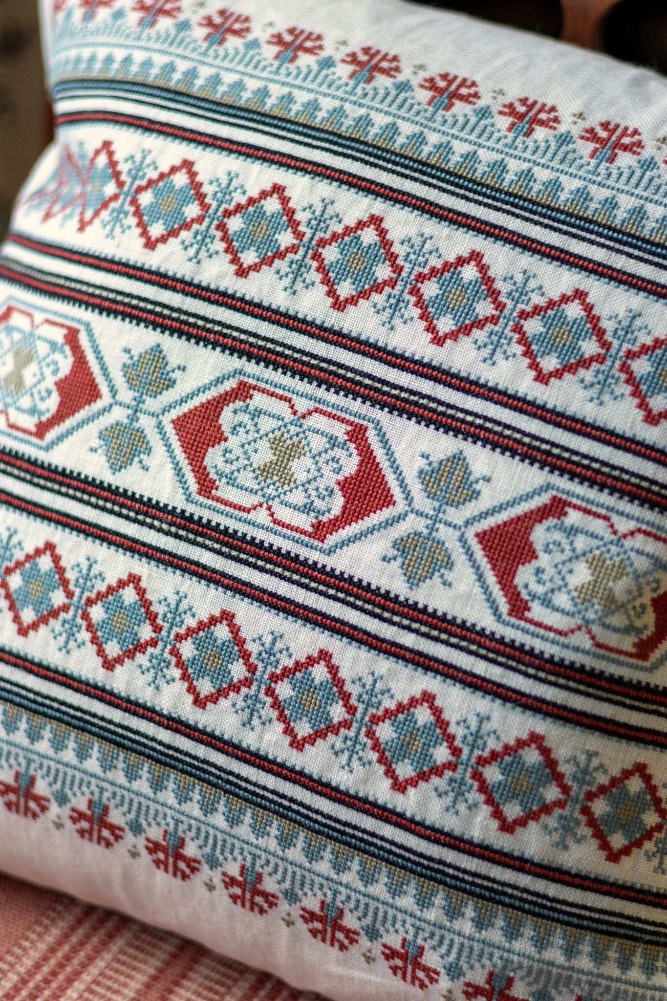 folk embroidery cushion with blue and red borders