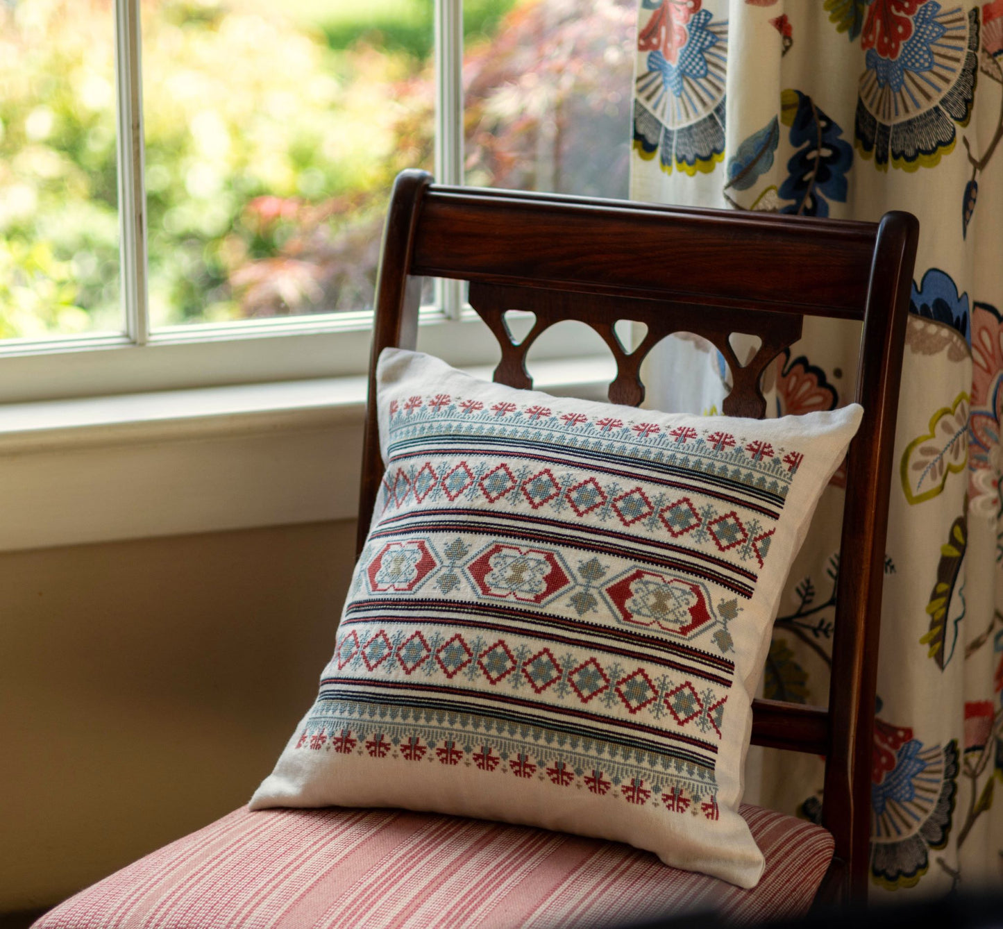 folk embroidery cushion with blue and red borders