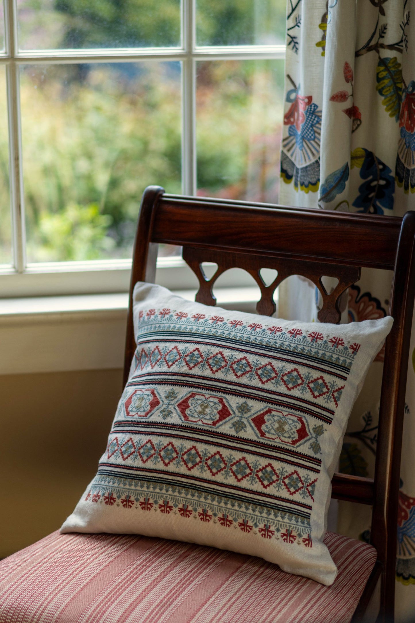 folk embroidery cushion with blue and red borders