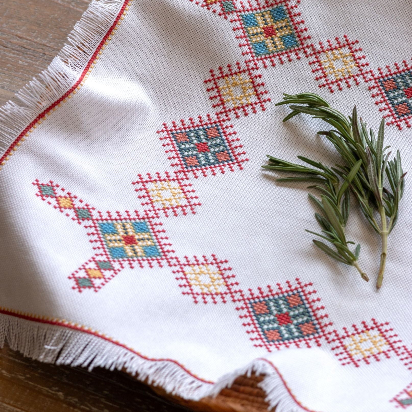 cross stitch folk embroidery Greek design basket cloth with herbs on table