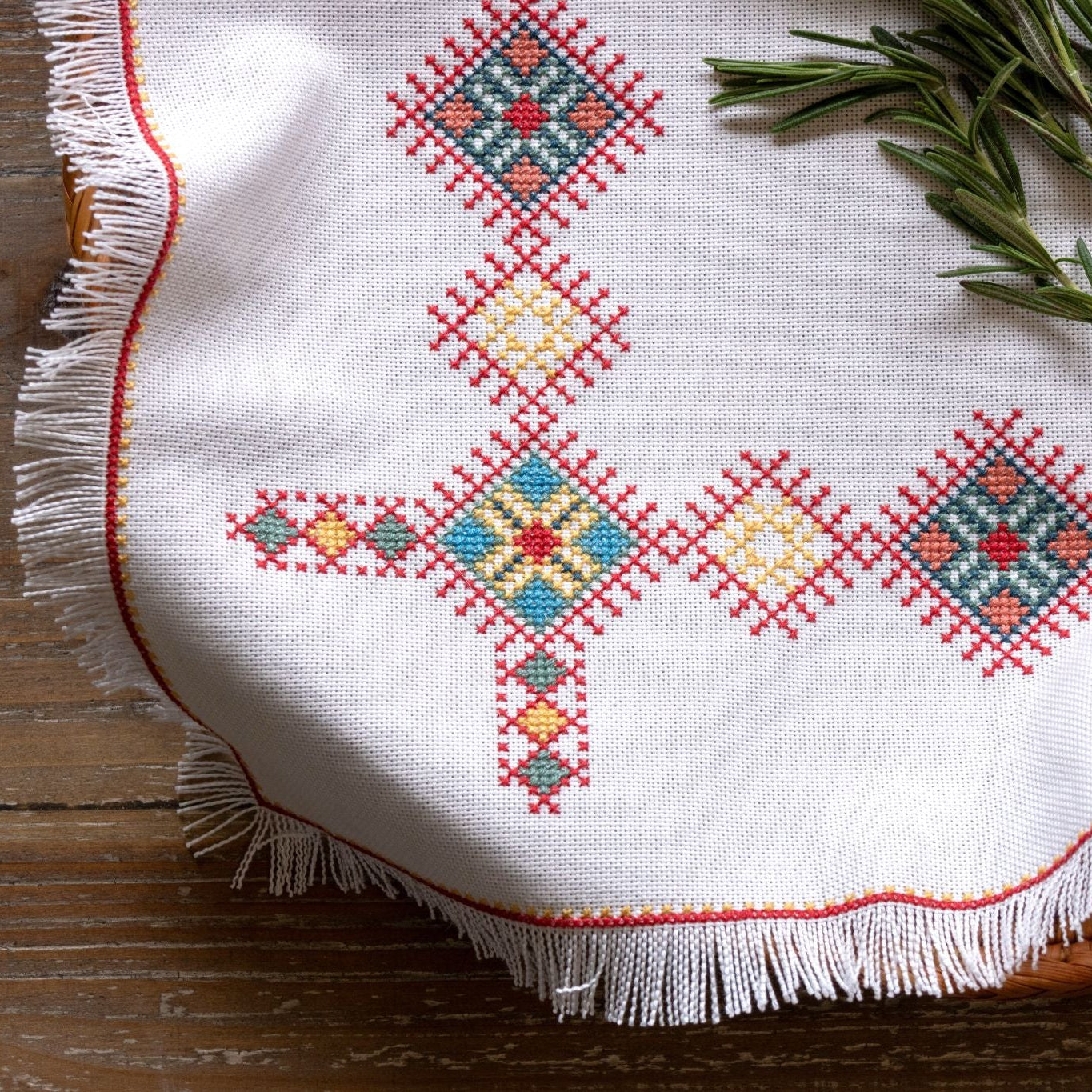 cross stitch folk embroidery Greek design basket cloth with herbs on table