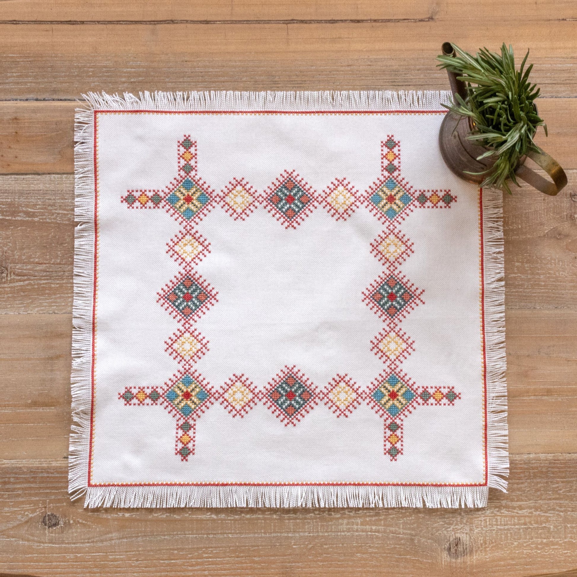 cross stitch folk embroidery Greek design basket cloth with herbs on table