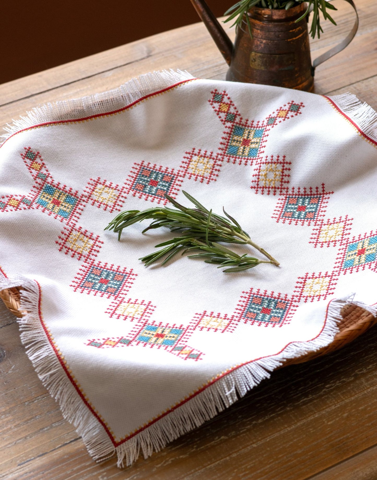cross stitch folk embroidery Greek design basket cloth with herbs on table