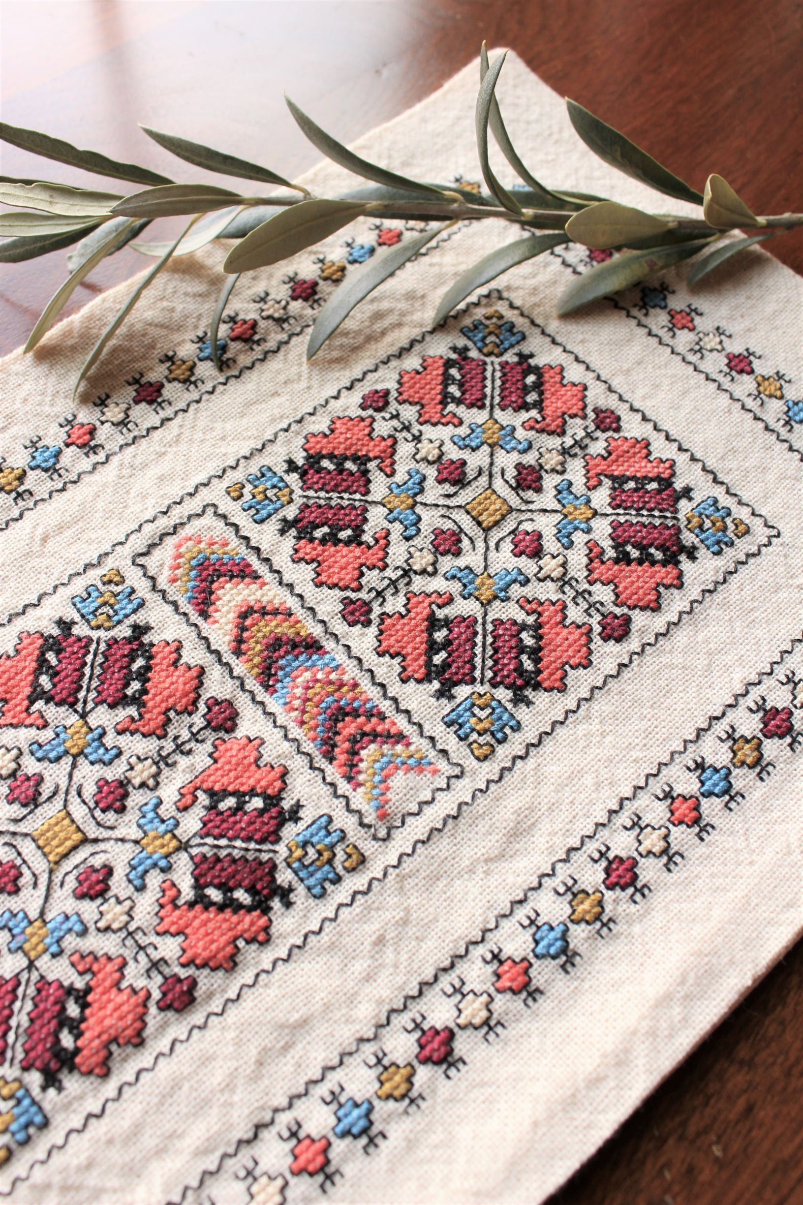 folk embroidery runner with coral and black design