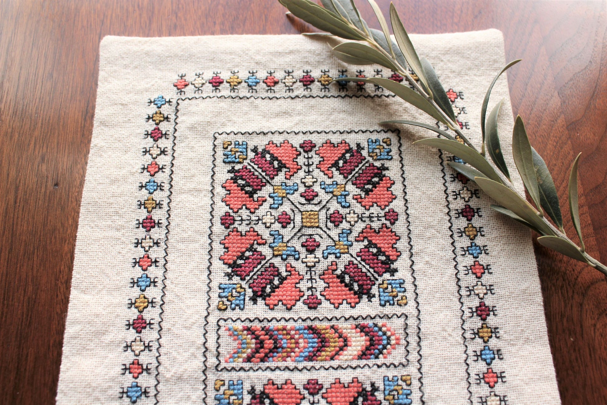 folk embroidery runner with coral and black design