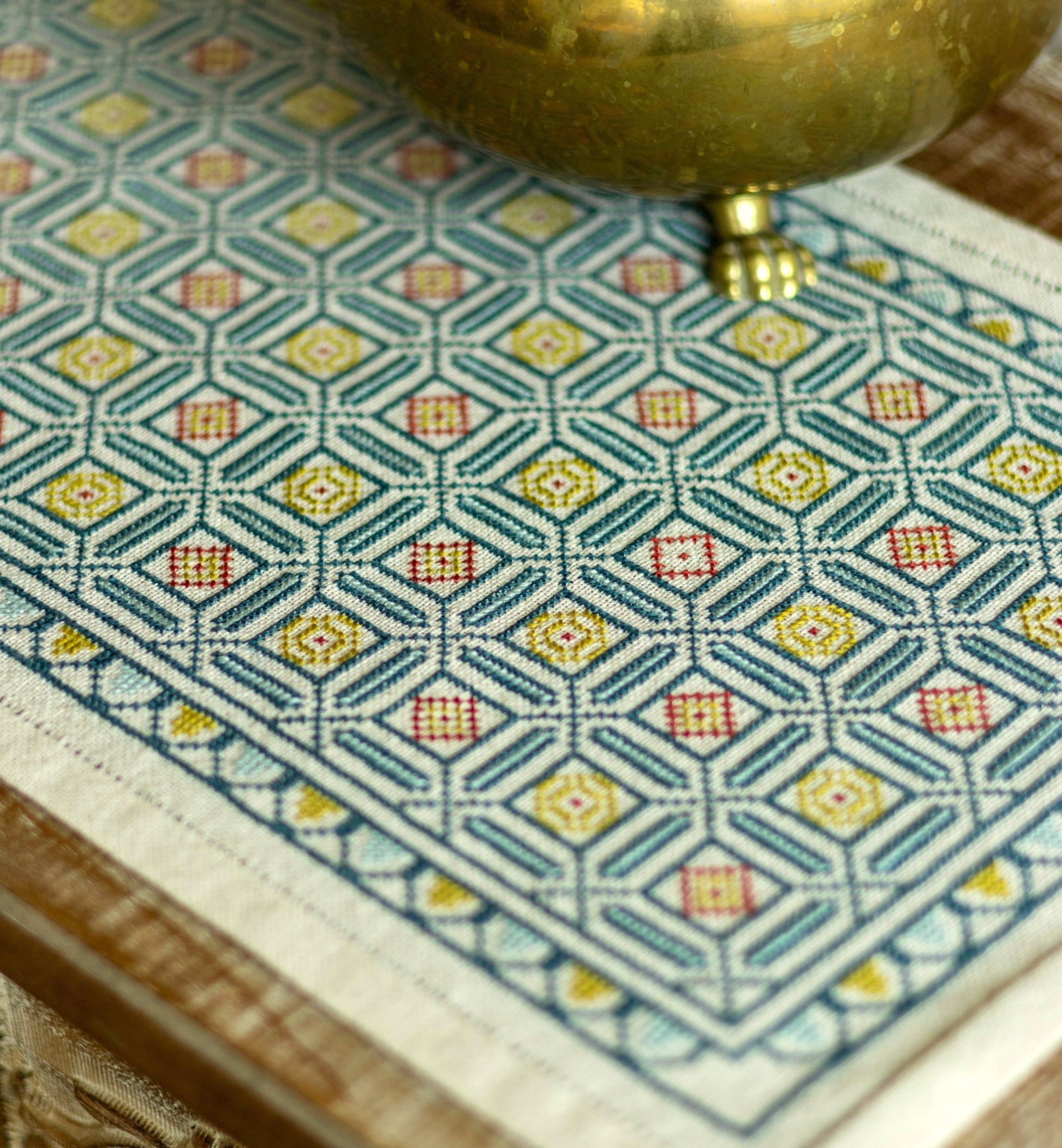 folk embroidery cross stitch with repeating mosaic tile design in blue and gold