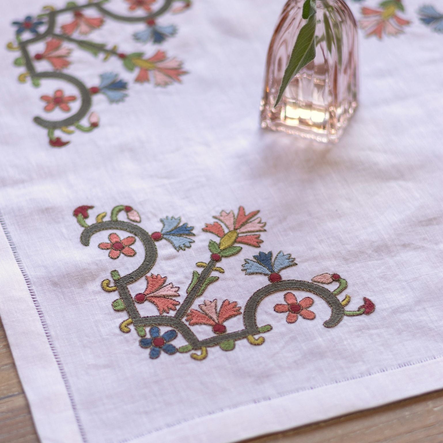 floral folk embroidery on white linen with pink vase