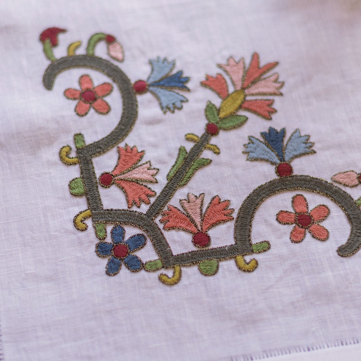 floral folk embroidery on white linen closeup