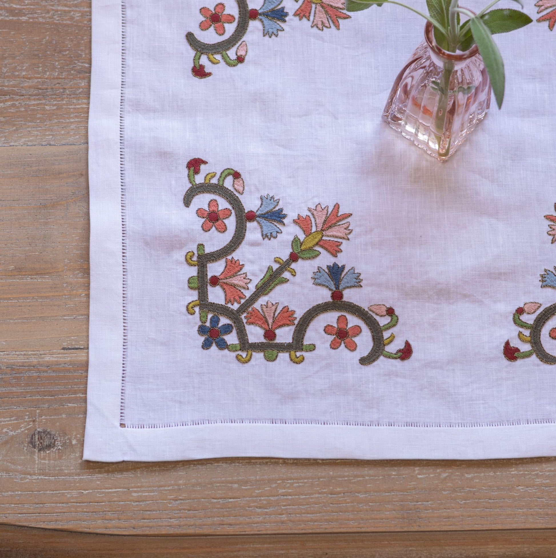 floral folk embroidery on white linen with pink vase