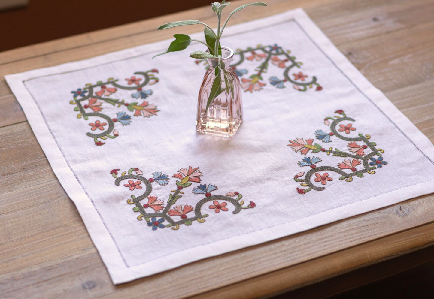 floral folk embroidery on white linen with pink vase