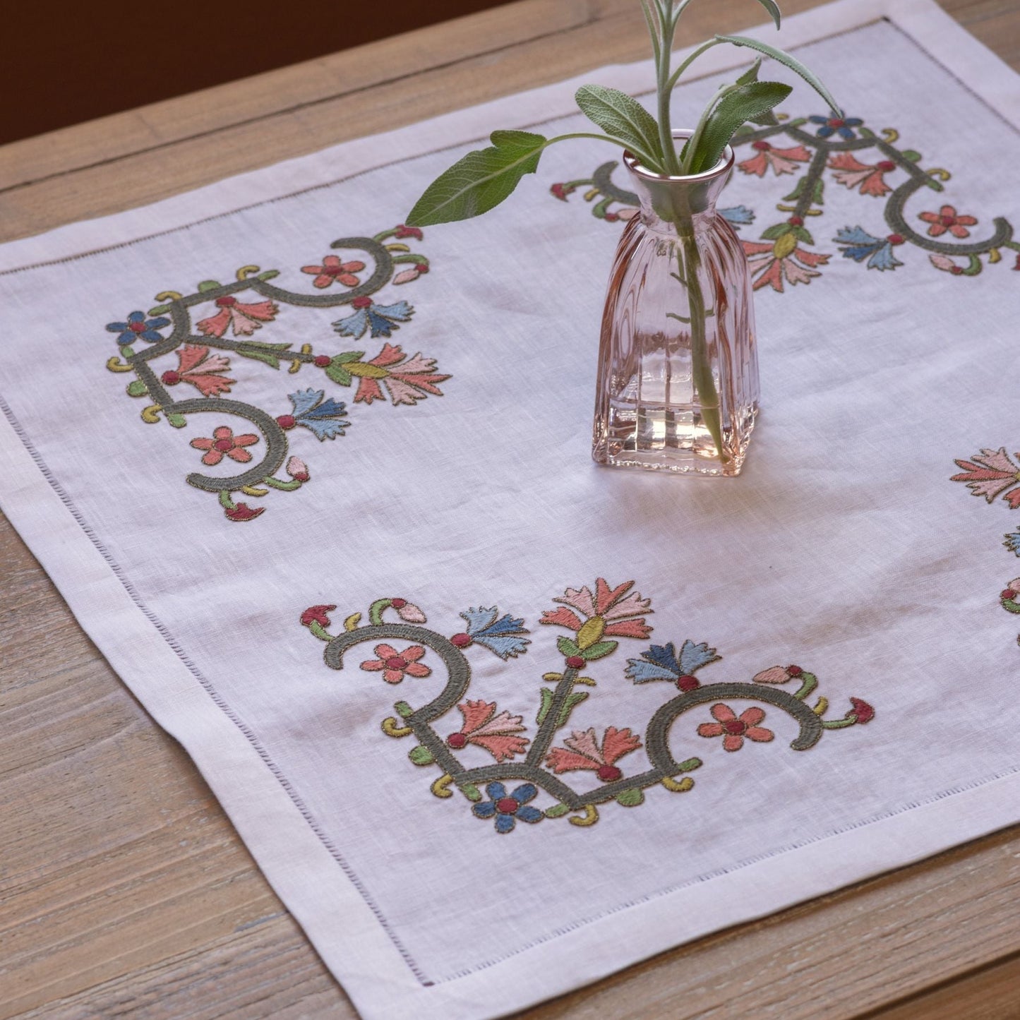 floral folk embroidery on white linen with pink vase