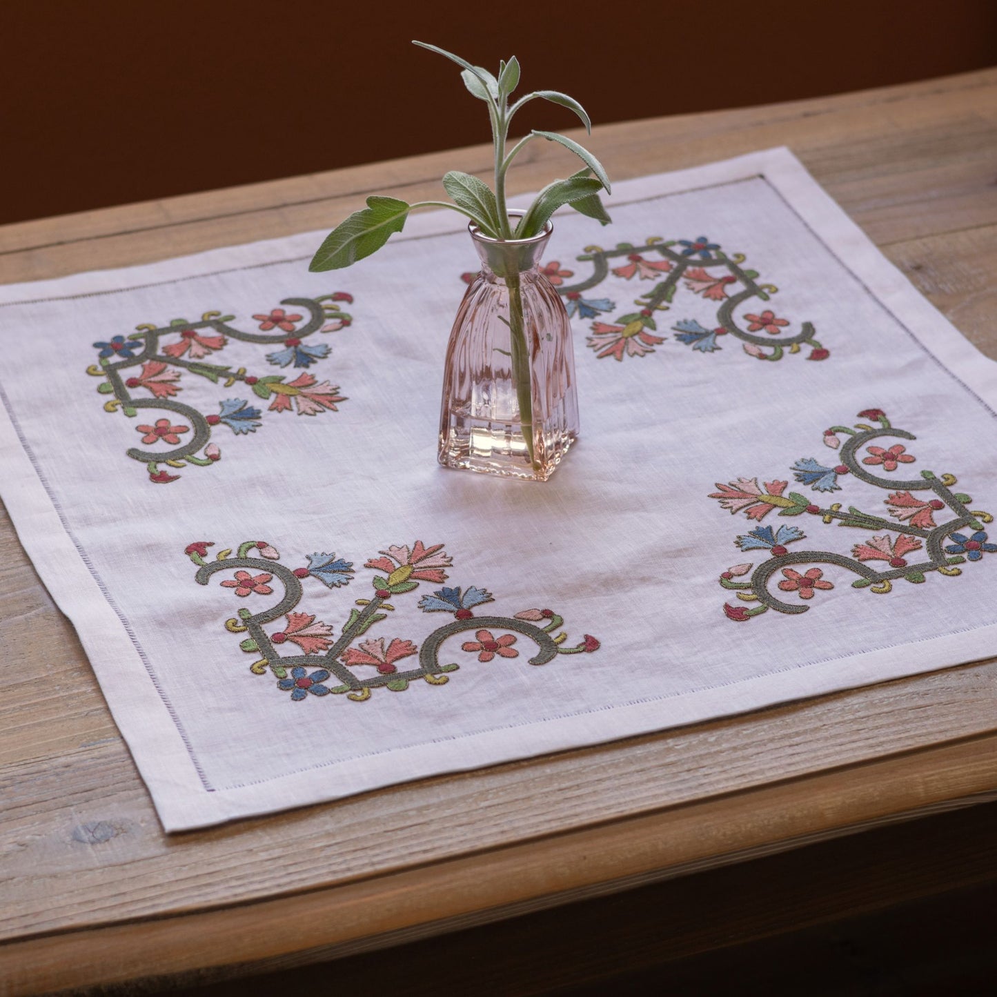 floral folk embroidery on white linen with pink vase