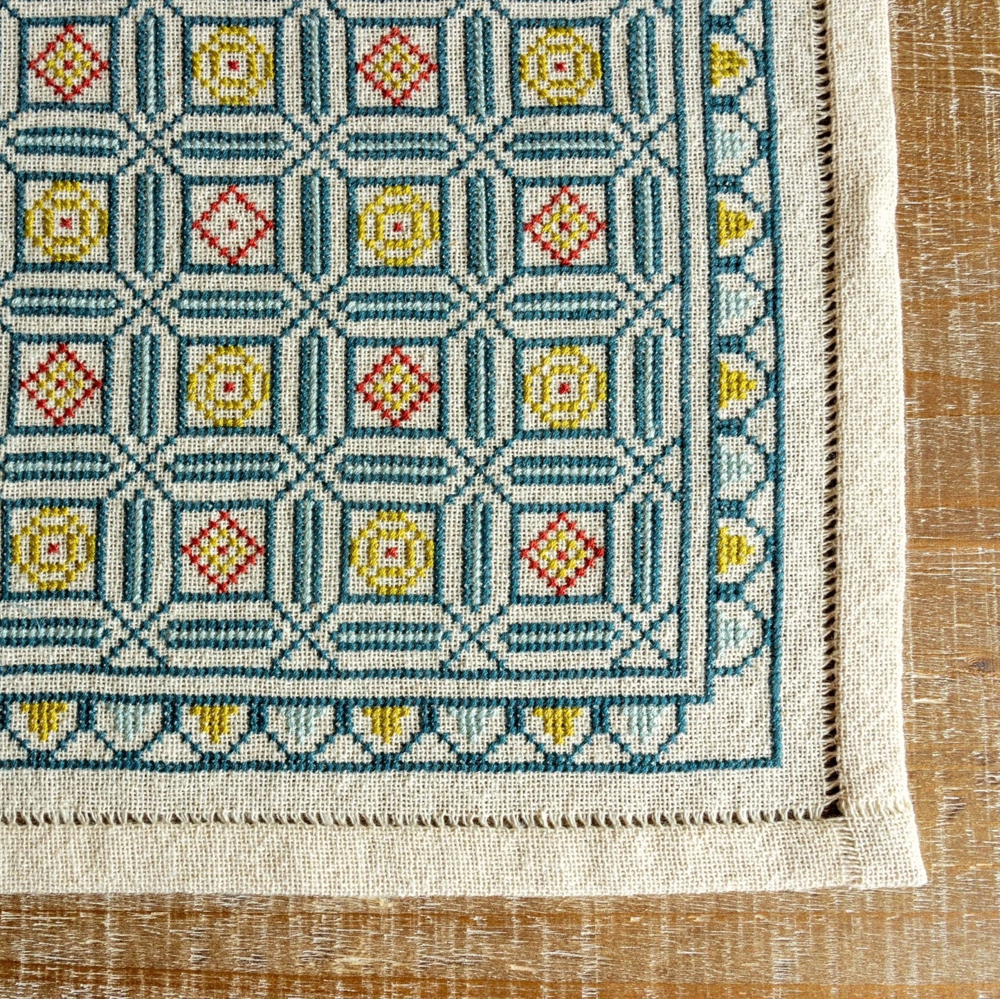 folk embroidery cross stitch with repeating mosaic tile design in blue and gold