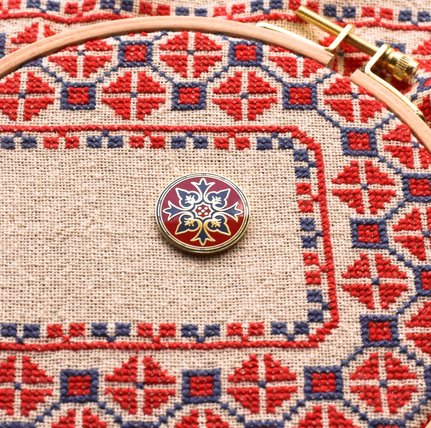 folk embroidery with embroidery needleminder with red and blue cross and leaf motif